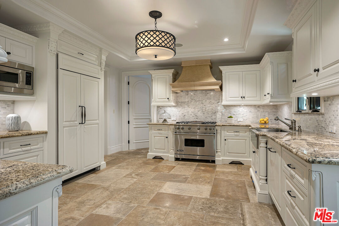 11025 Anzio Road Los Angeles, CA 90077 - Photo 17 of 34 a kitchen with granite countertop a sink and cabinets