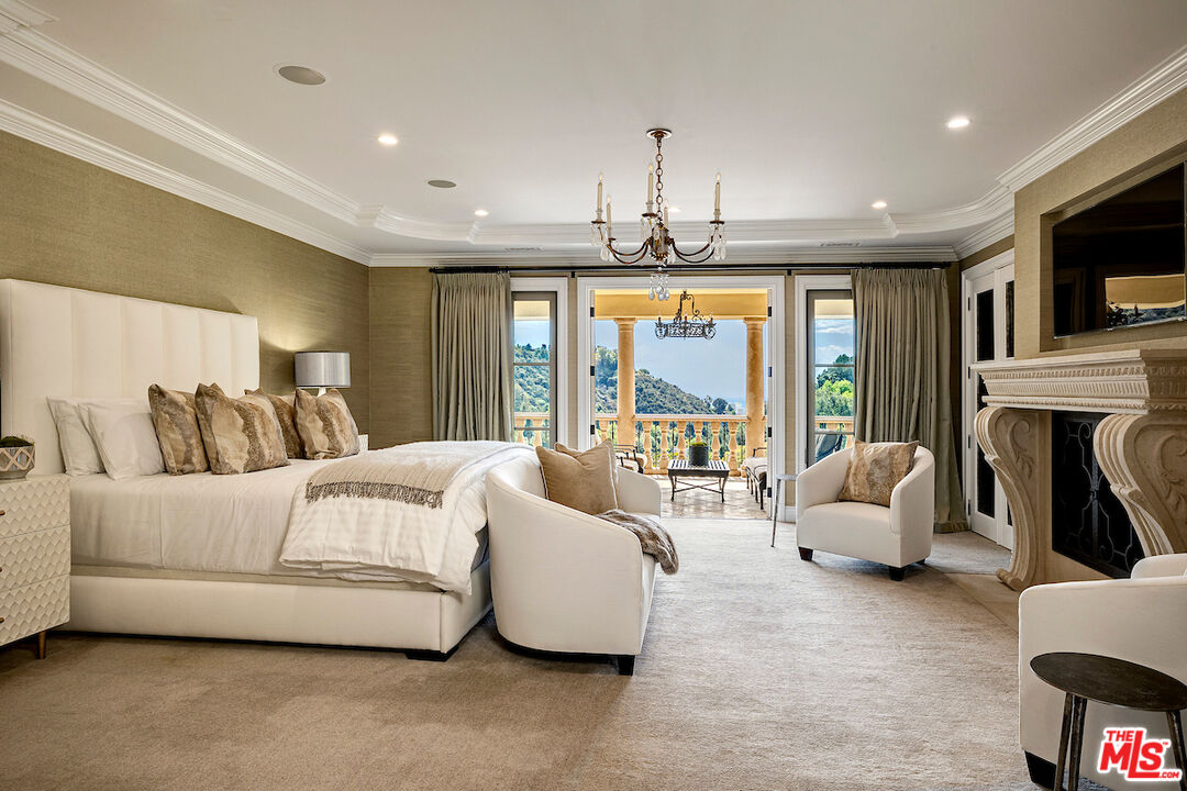 11025 Anzio Road Los Angeles, CA 90077 - Photo 21 of 34 a spacious bedroom with a bed and glass window