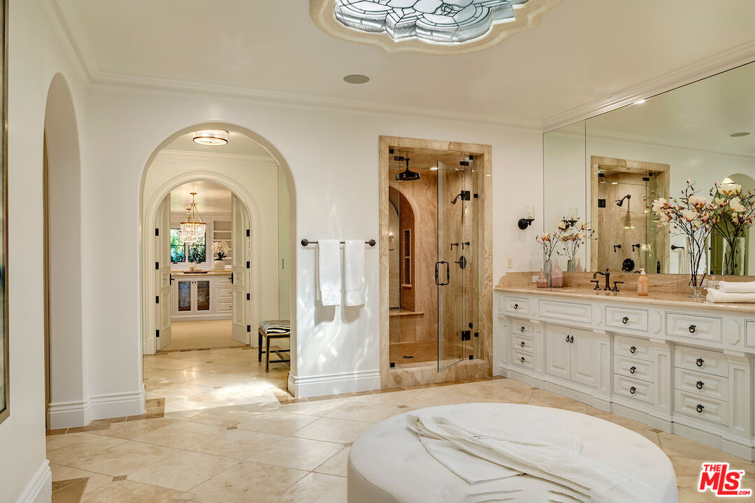 11025 Anzio Road Los Angeles, CA 90077 - Photo 25 of 34 a spacious bathroom with a shower a sink and mirror