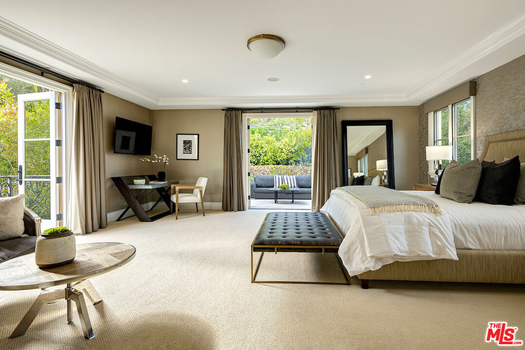 11025 Anzio Road Los Angeles, CA 90077 - Photo 27 of 34 a spacious bedroom with a bed and large windows