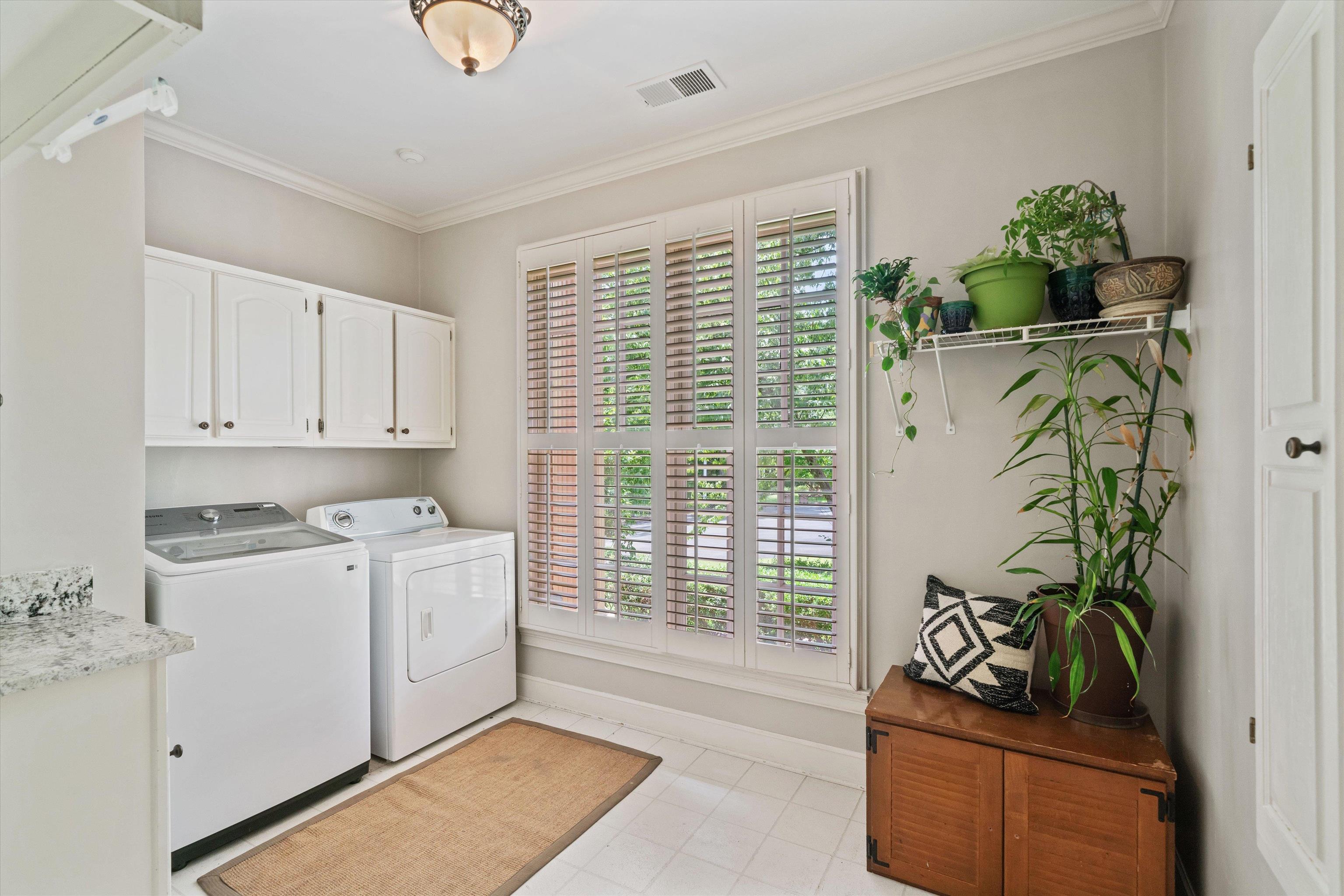 8897 Forest Ridge Cove Memphis, TN 38018 - Photo 14 of 35 Laundry room with washer and dryer, cabinet space, healthy amount of natural light, and ornamental molding