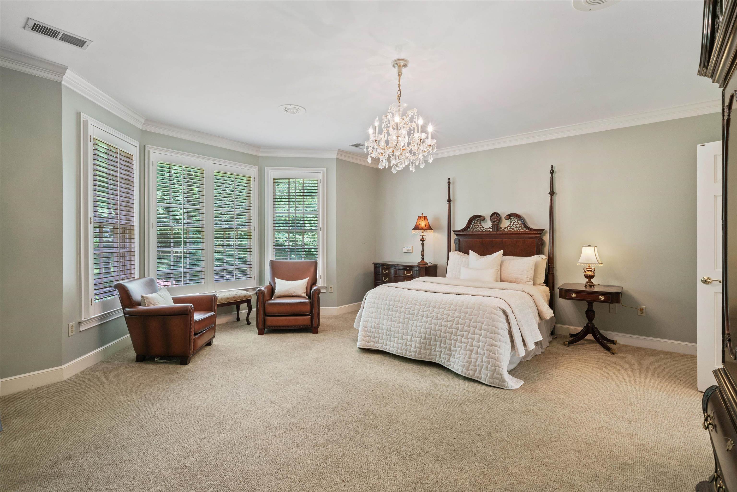 8897 Forest Ridge Cove Memphis, TN 38018 - Photo 15 of 35 Bedroom with ornamental molding, light carpet, and a chandelier