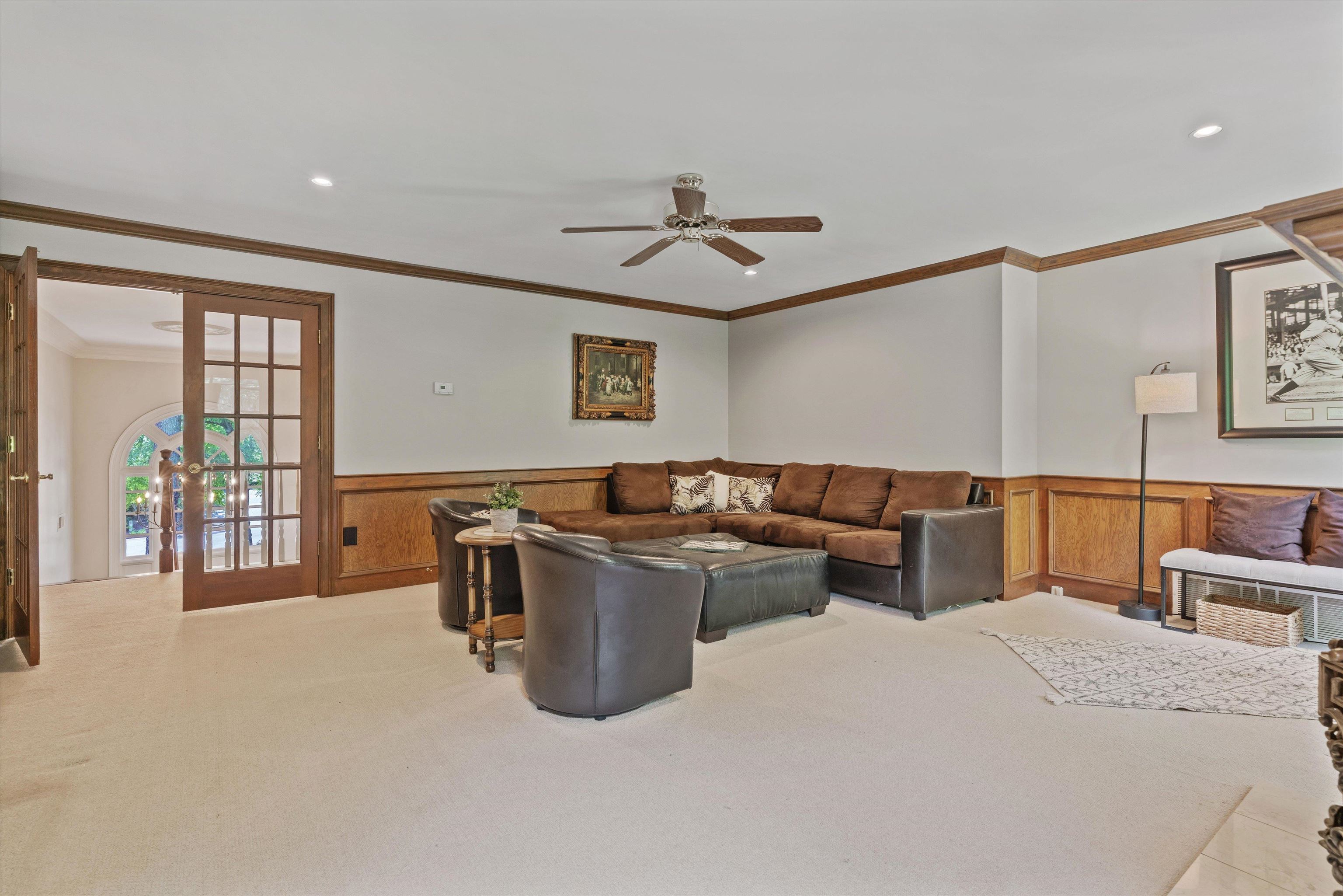 8897 Forest Ridge Cove Memphis, TN 38018 - Photo 27 of 35 Carpeted living area featuring wainscoting, crown molding, ceiling fan, recessed lighting, and french doors