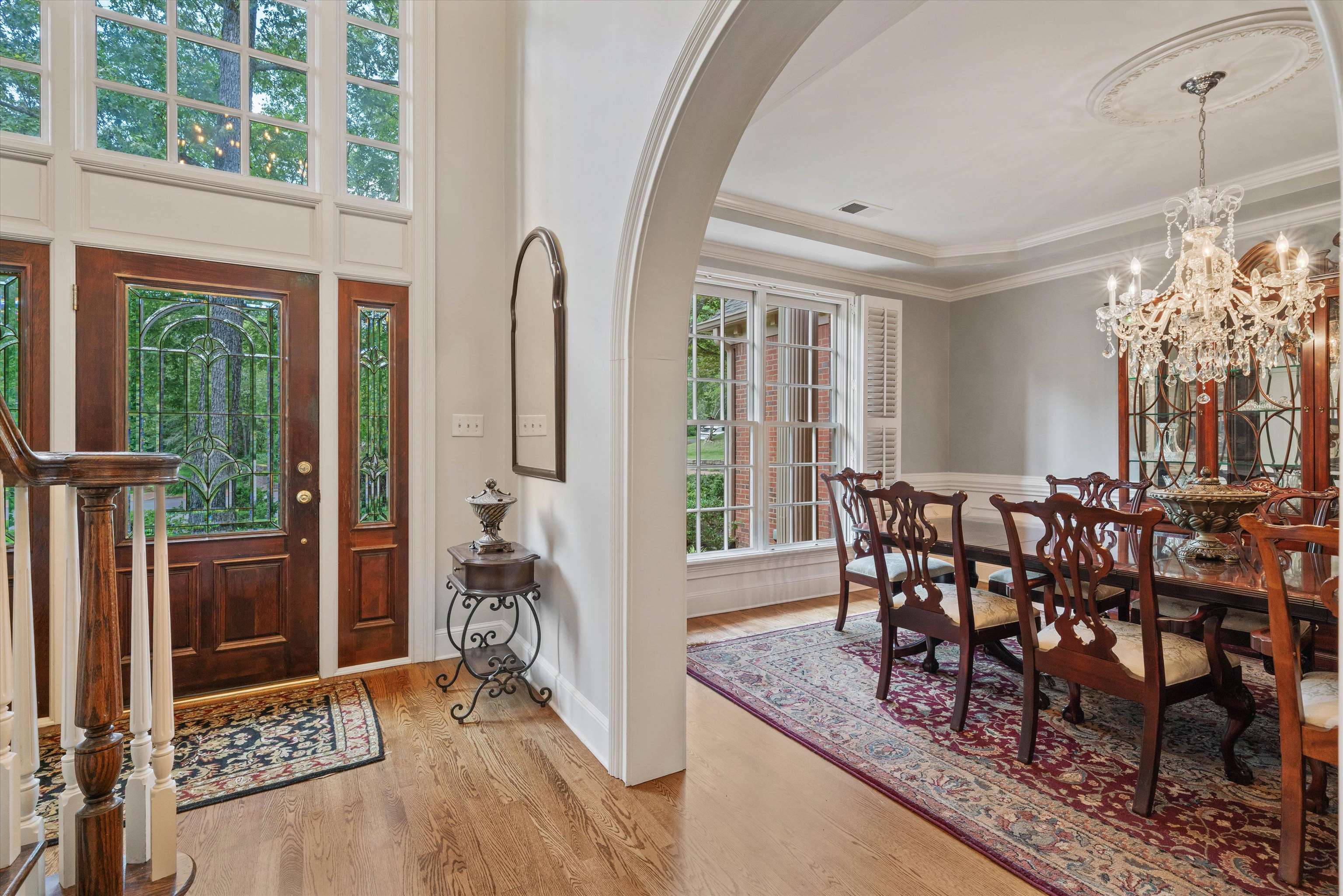 8897 Forest Ridge Cove Memphis, TN 38018 - Photo 4 of 35 Foyer featuring arched walkways, light wood-style flooring, crown molding, a chandelier, and a tray ceiling
