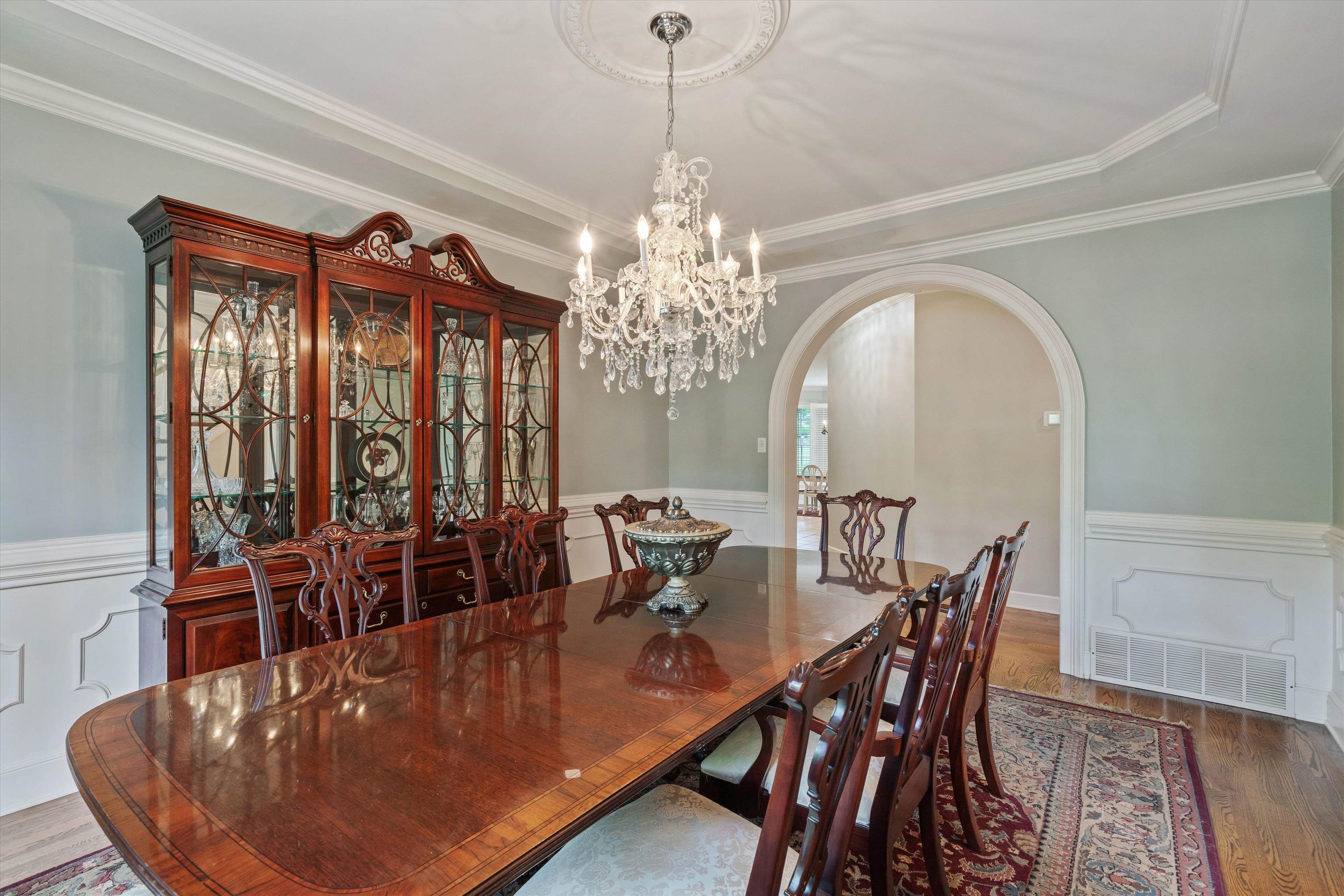 8897 Forest Ridge Cove Memphis, TN 38018 - Photo 5 of 35 Dining area with arched walkways, wood finished floors, crown molding, a wainscoted wall, and a chandelier