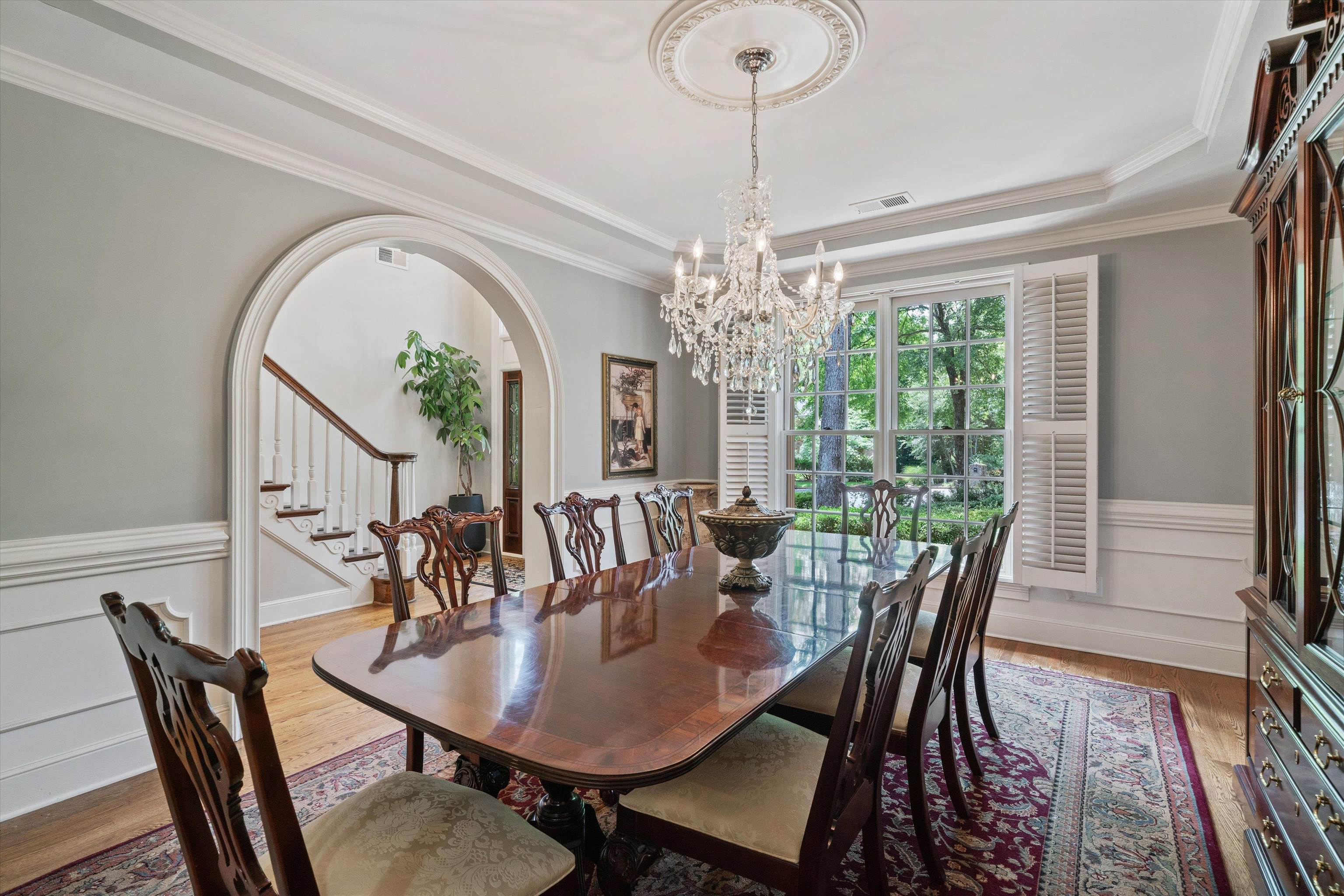 8897 Forest Ridge Cove Memphis, TN 38018 - Photo 6 of 35 Dining area featuring arched walkways, a chandelier, stairs, light wood-type flooring, and a raised ceiling