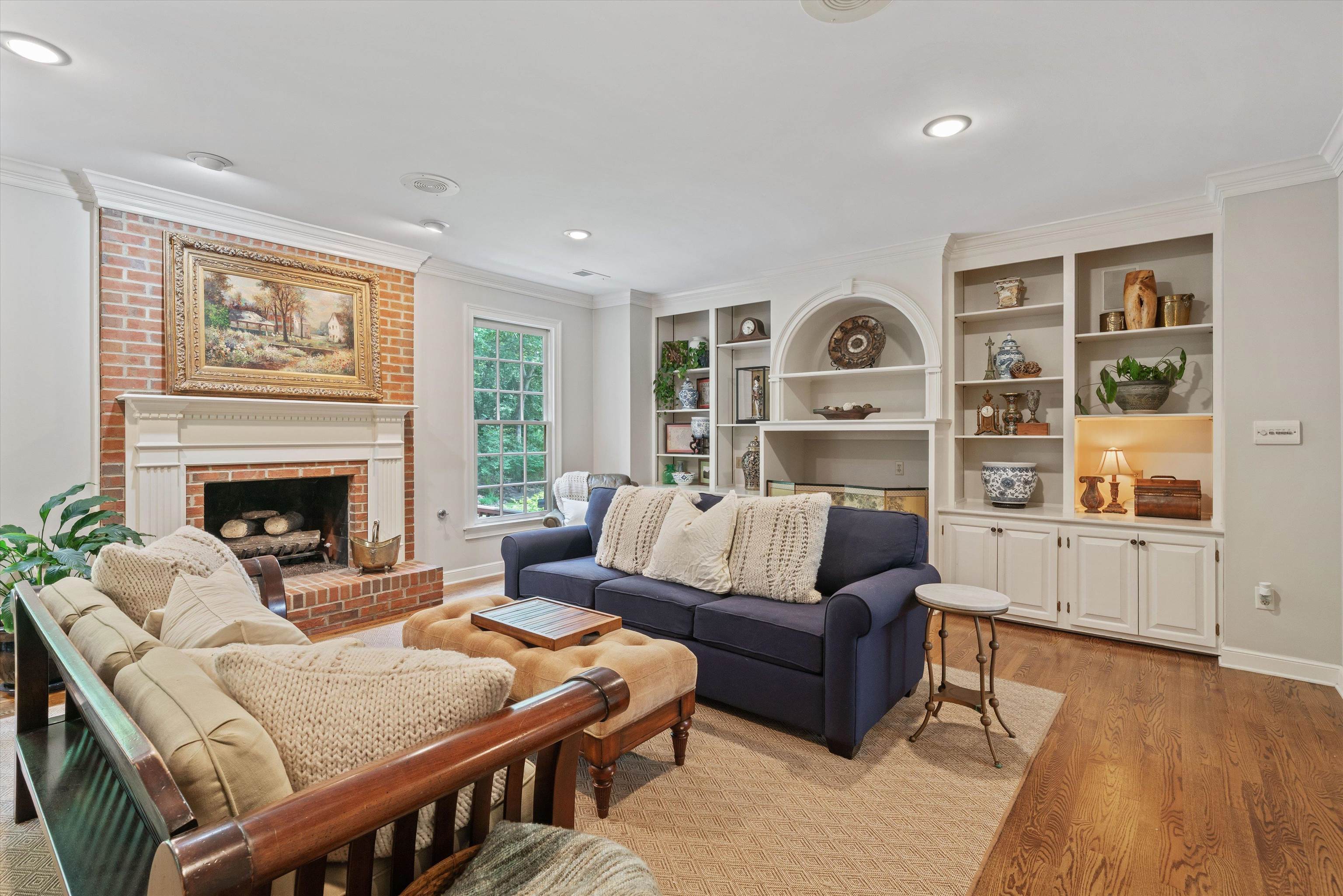 8897 Forest Ridge Cove Memphis, TN 38018 - Photo 7 of 35 Living room with ornamental molding, light wood-type flooring, a brick fireplace, recessed lighting, and built in shelves