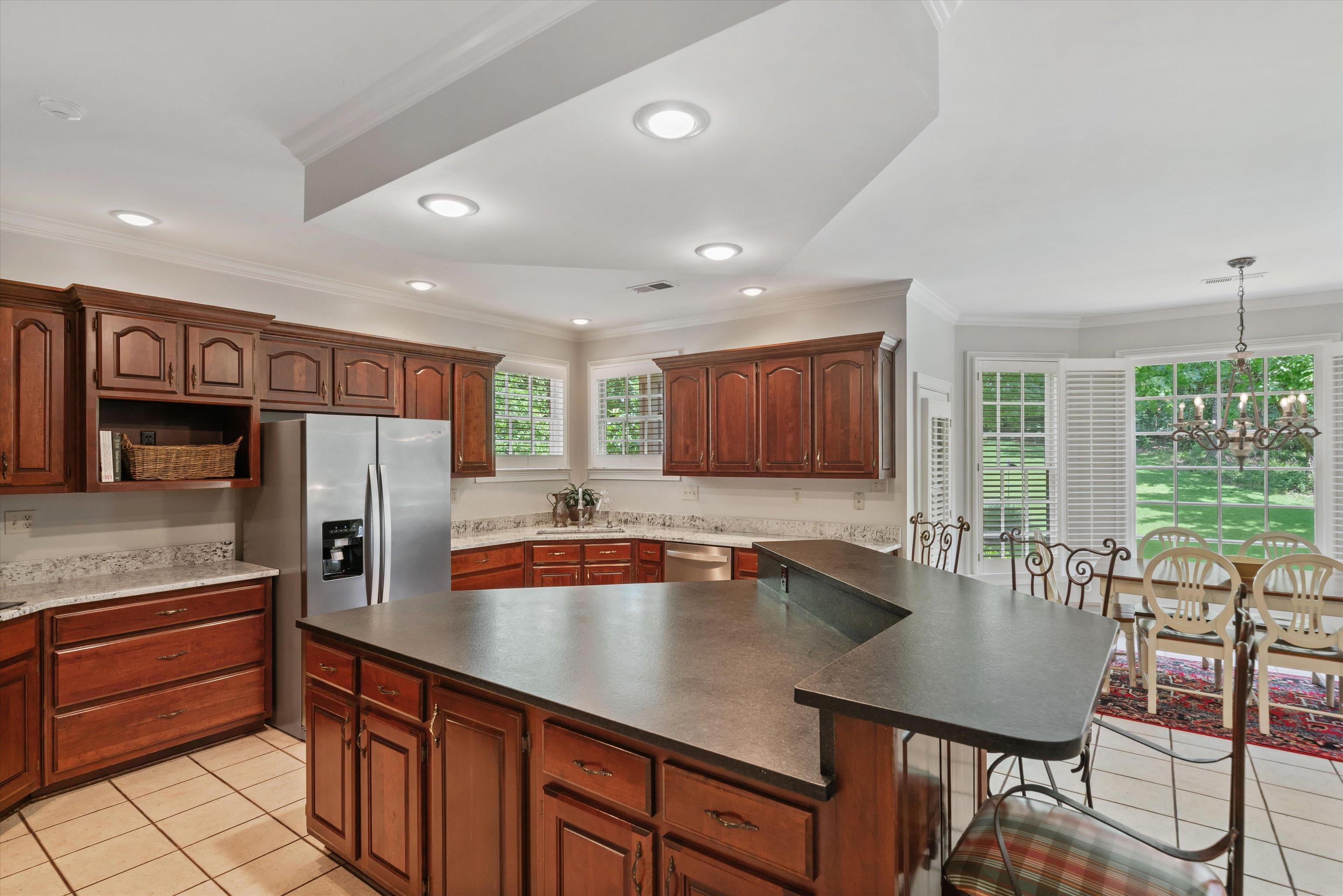 8897 Forest Ridge Cove Memphis, TN 38018 - Photo 9 of 35 Kitchen featuring appliances with stainless steel finishes, light tile patterned floors, plenty of natural light, a breakfast bar area, and crown molding