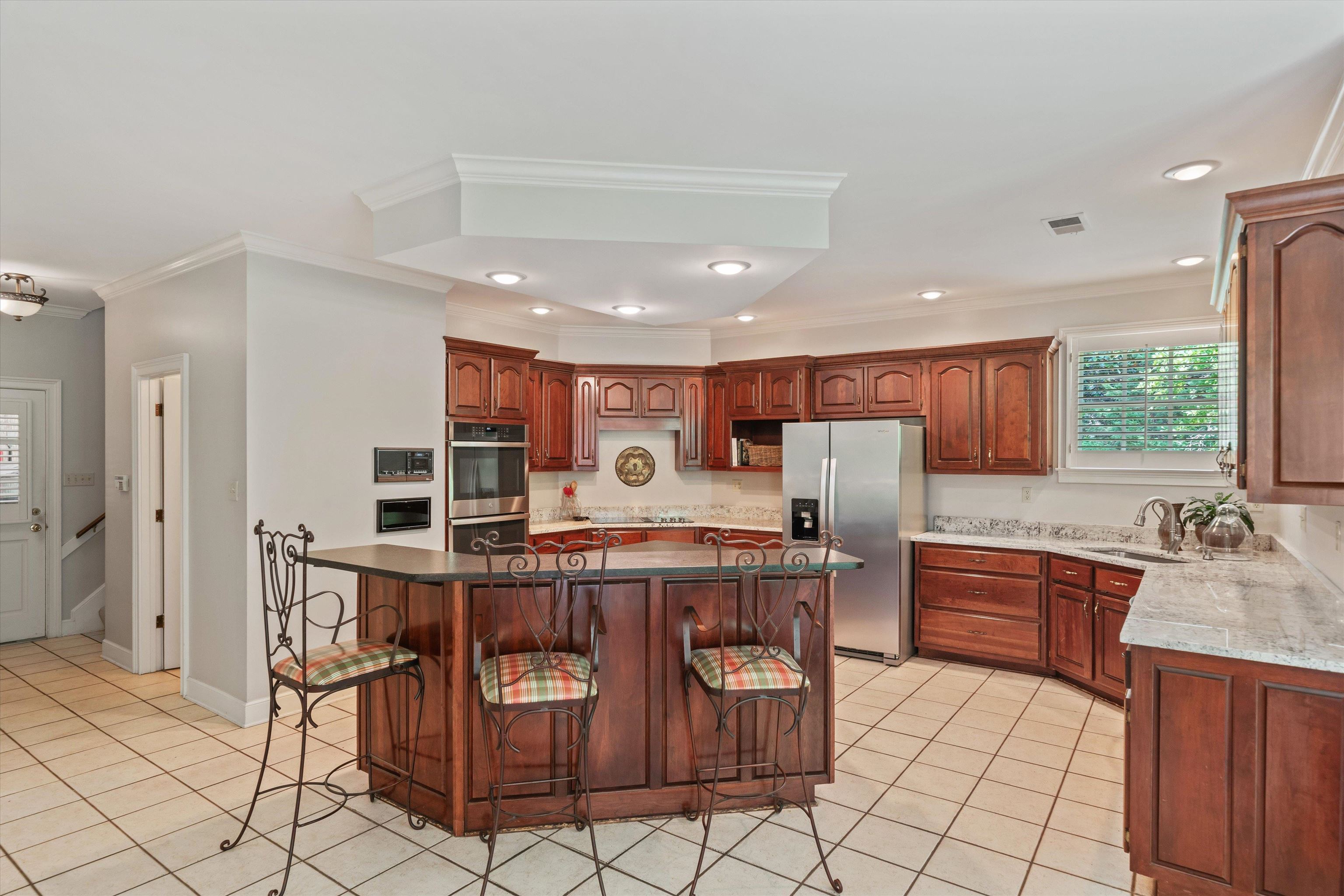 8897 Forest Ridge Cove Memphis, TN 38018 - Photo 10 of 35 Kitchen with appliances with stainless steel finishes, ornamental molding, light tile patterned floors, a kitchen breakfast bar, and recessed lighting