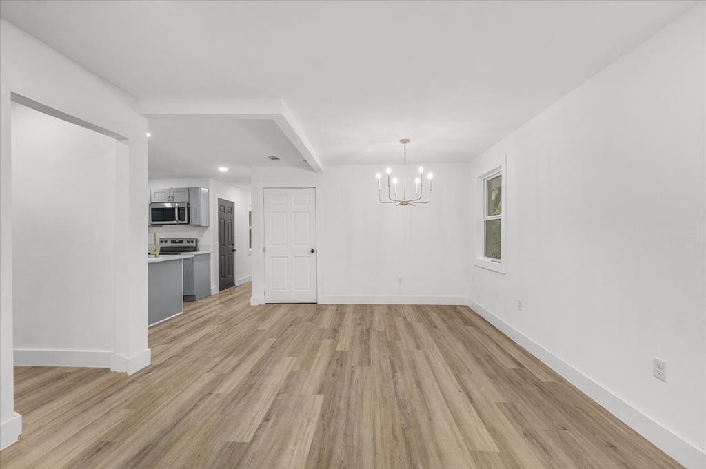 3301 Hedrick Street Fort Worth, TX 76111 - Photo 11 of 28 a view of empty room with wooden floor and kitchen