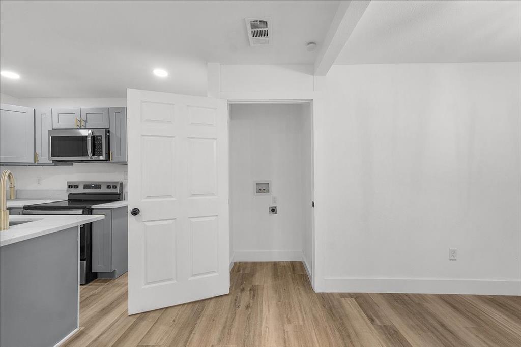 3301 Hedrick Street Fort Worth, TX 76111 - Photo 12 of 28 a view of a kitchen with wooden floor and electronic appliances