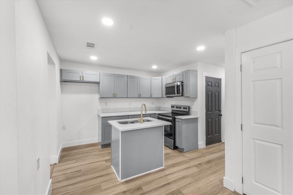 3301 Hedrick Street Fort Worth, TX 76111 - Photo 14 of 28 a kitchen with stainless steel appliances granite countertop a stove and a refrigerator