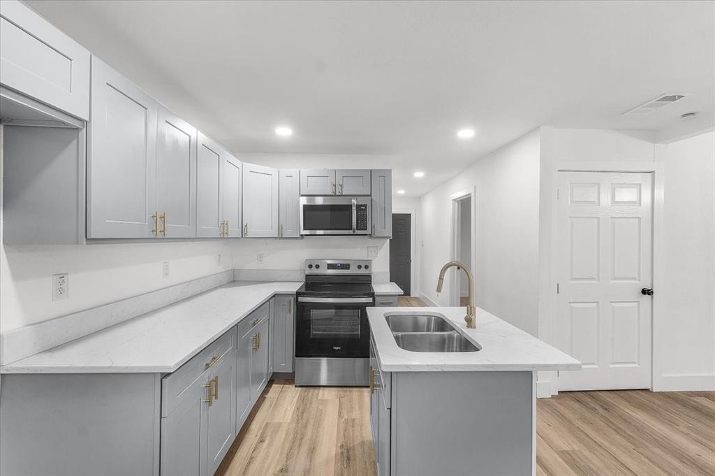 3301 Hedrick Street Fort Worth, TX 76111 - Photo 17 of 28 a kitchen with a sink a stove and cabinets