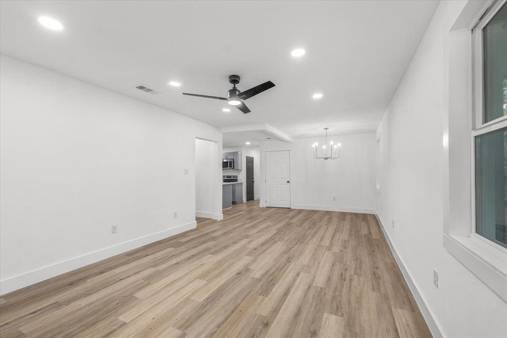 3301 Hedrick Street Fort Worth, TX 76111 - Photo 10 of 28 an empty room with wooden floor and a ceiling fan