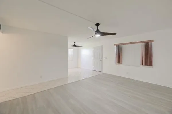 a view of an empty room with wooden floor
