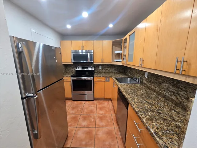 a kitchen with stainless steel appliances granite countertop a refrigerator stove and sink