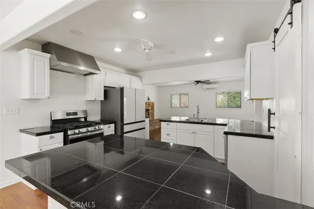 a kitchen with stainless steel appliances kitchen island granite countertop a sink and cabinets