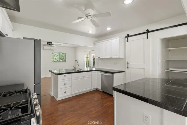 a kitchen with granite countertop a sink stainless steel appliances and cabinets