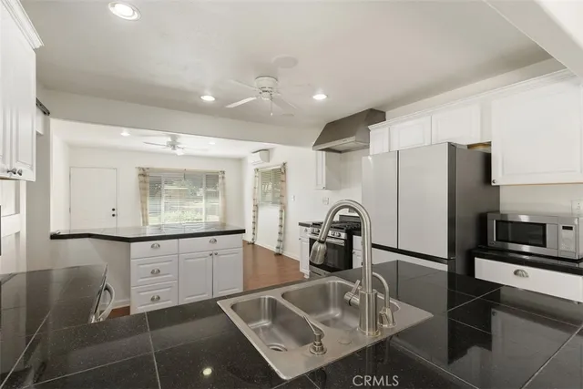 a kitchen with granite countertop a sink appliances and cabinets