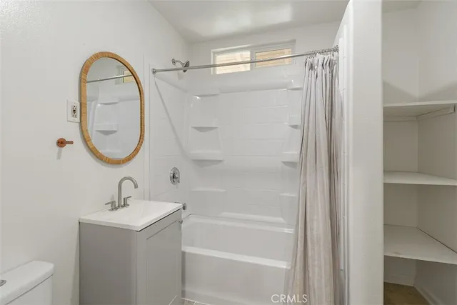 a bathroom with a sink a mirror a toilet and a shower