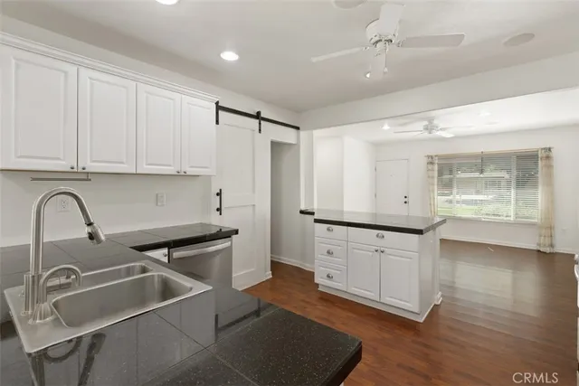 a kitchen with a sink cabinets and wooden floor