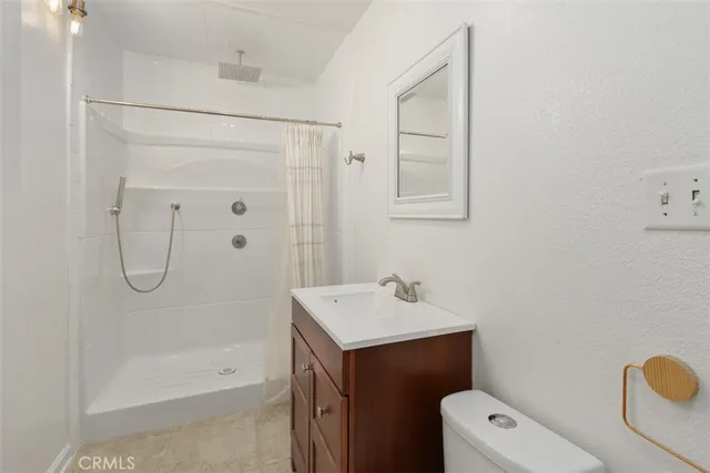 a bathroom with a shower a sink a toilet and a mirror