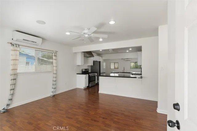 a open kitchen with white cabinets and wooden floor