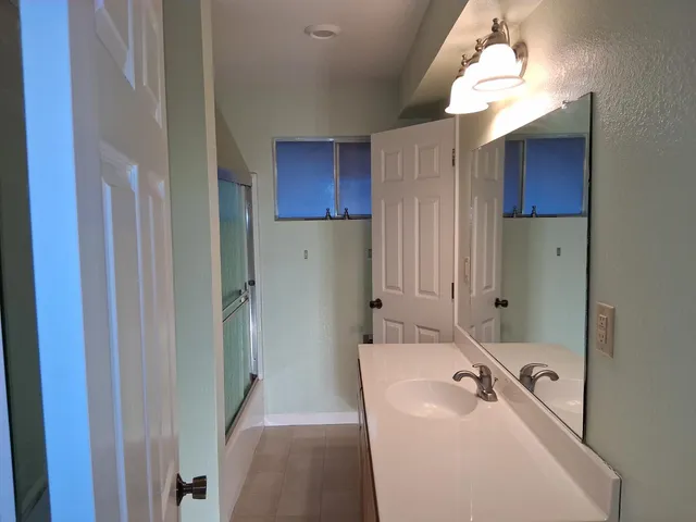 a bathroom with a tub sink and mirror