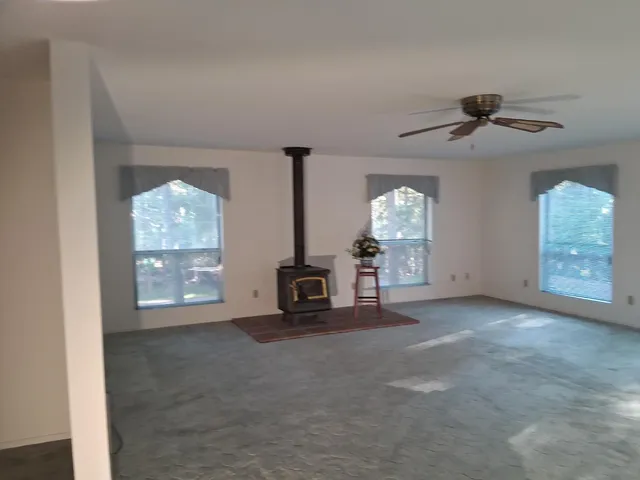 an empty room with windows and fireplace