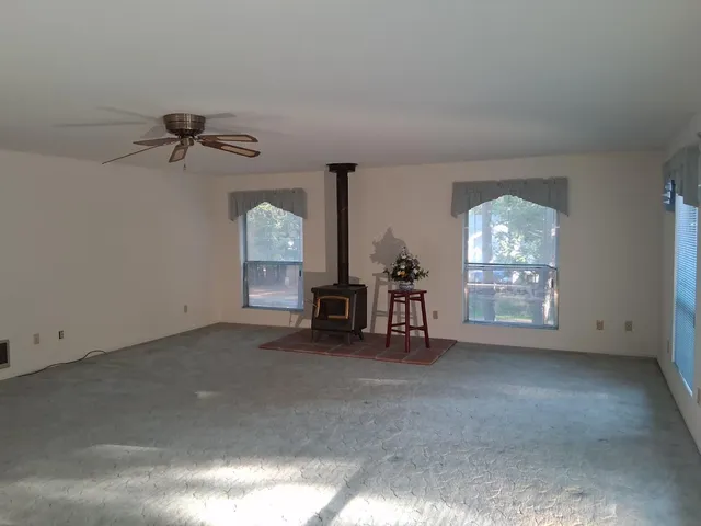 an empty room with windows and fan