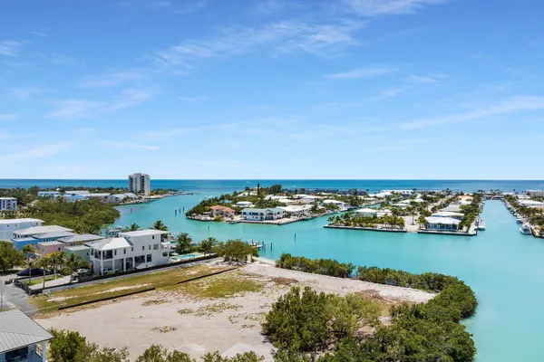 an aerial view of ocean and residential houses with outdoor space