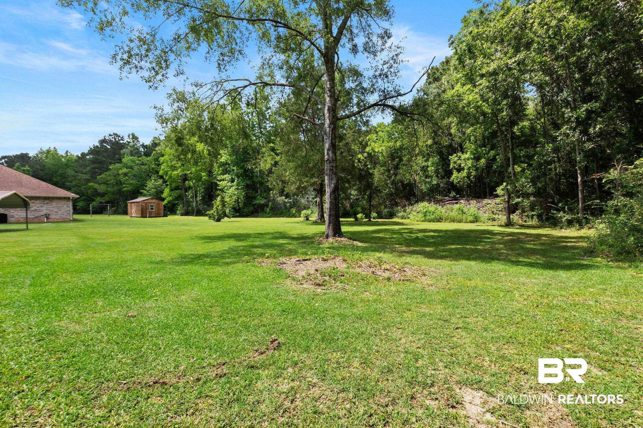 16151 Tolbert Road Bay Minette, AL 36507 - Photo 59 of 74 Expansive green lawn with mature trees and a detached shed