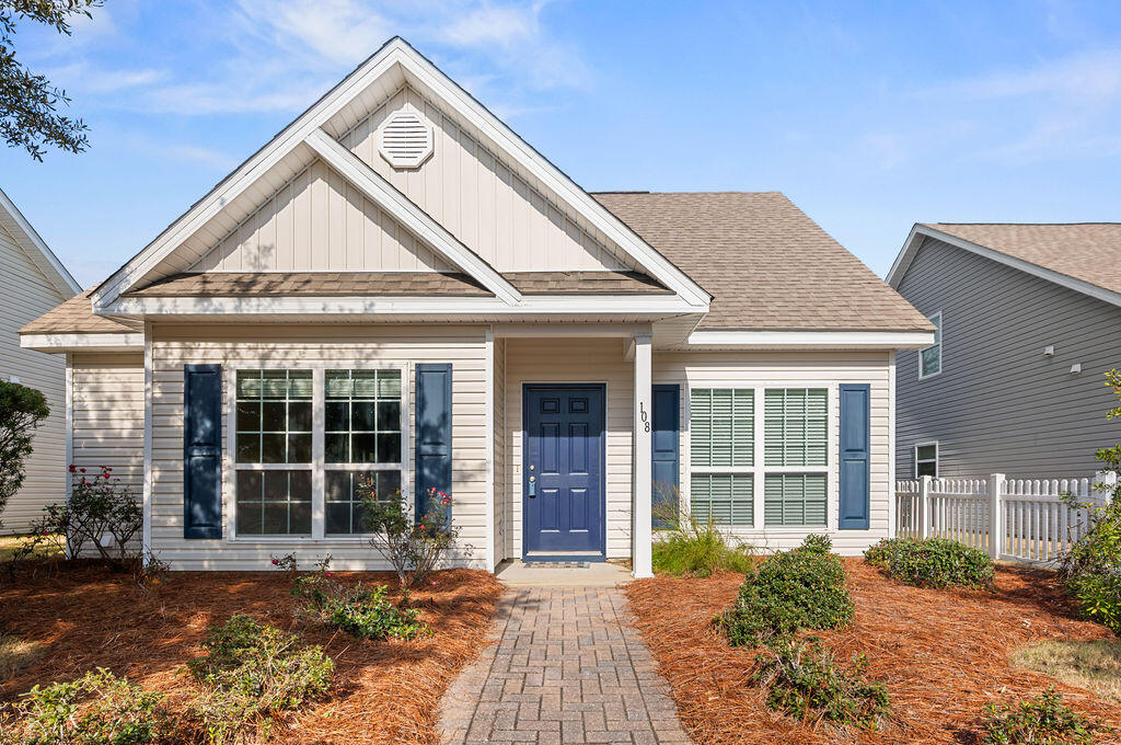 a view of a house with wooden door and a yard