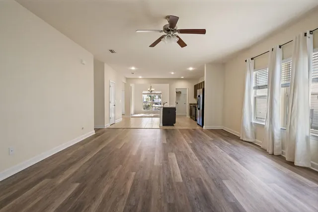 an empty room with windows and fan