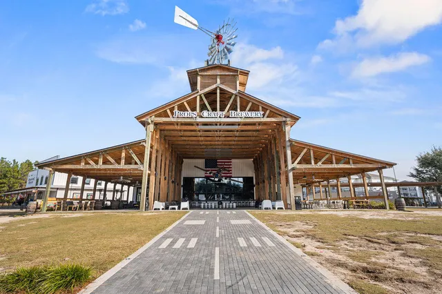 a view of a park with large trees and wooden fence