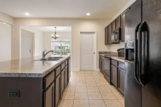 a kitchen with stainless steel appliances granite countertop a stove a sink and a microwave