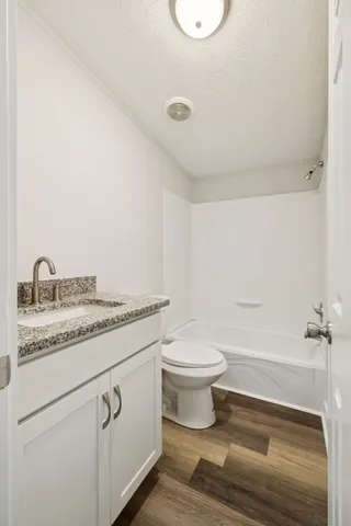 a bathroom with a granite countertop sink a toilet and a mirror