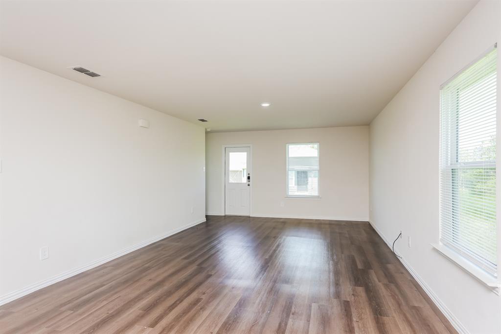 433 Shorty Street Mabank, TX 75147 - Photo 4 of 21 Spare room with baseboards, dark wood-style floors, visible vents, and a wealth of natural light
