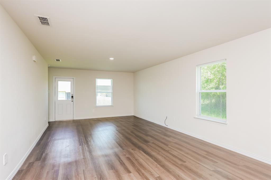 433 Shorty Street Mabank, TX 75147 - Photo 5 of 21 Unfurnished room with plenty of natural light, visible vents, baseboards, and wood finished floors