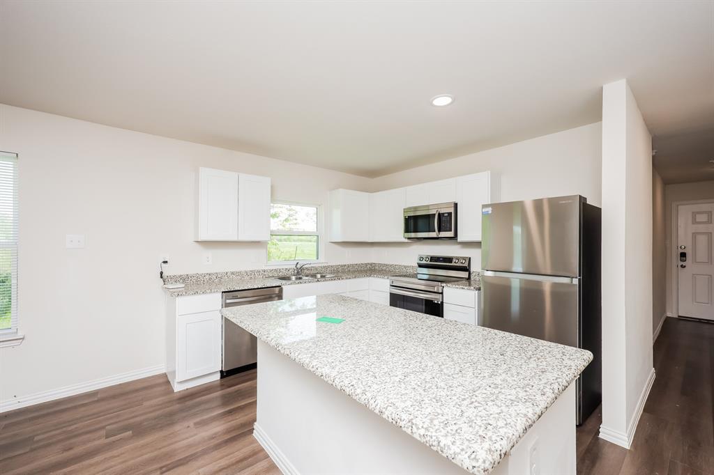 433 Shorty Street Mabank, TX 75147 - Photo 10 of 21 Kitchen with white cabinets, a center island, appliances with stainless steel finishes, dark wood-style flooring, and a sink