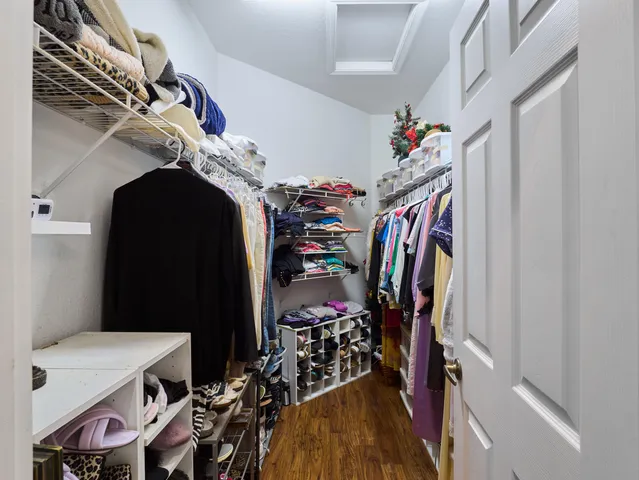 a view of walk in closet with clothes and shoes