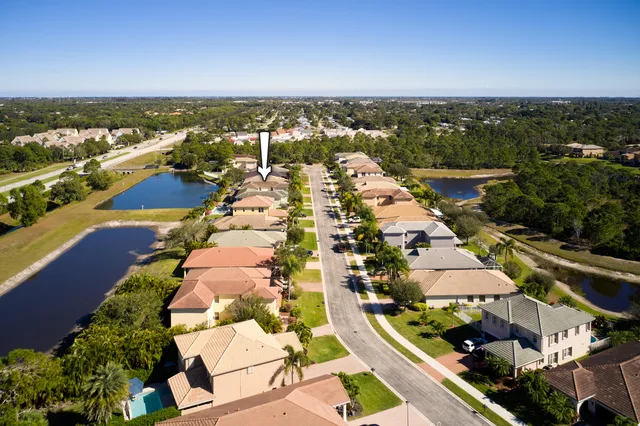 an aerial view of residential houses with outdoor space and trees