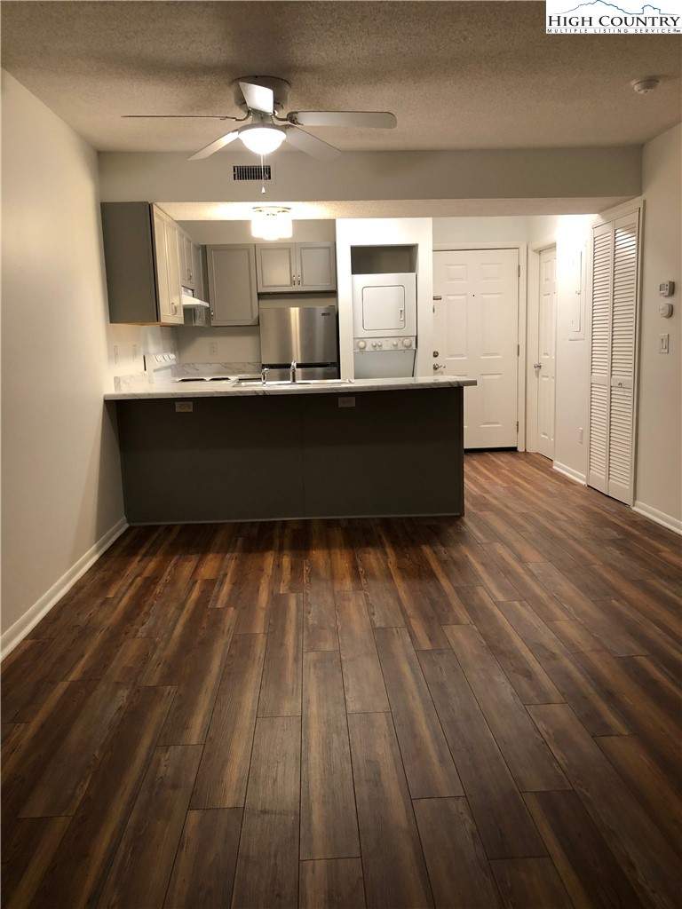 229 East King Street, Unit 9(1I) Boone, NC 28607 - Photo 15 of 19 a living room with kitchen island granite countertop wooden floors and a sink