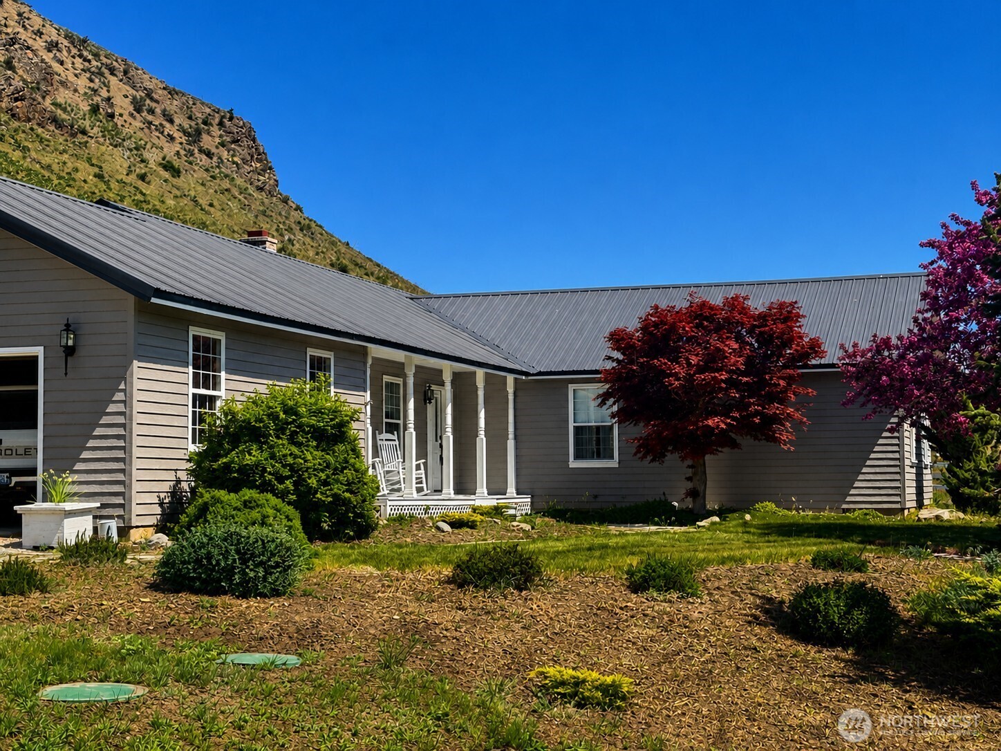 492 Pine Creek Road Tonasket, WA 98855 - Photo 1 of 37 a front view of a house with a garden