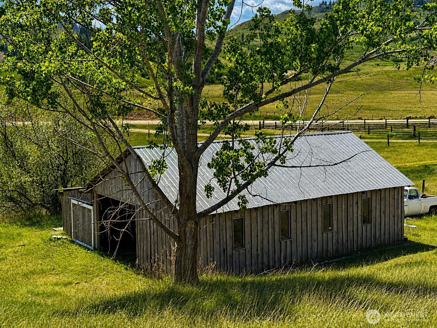 492 Pine Creek Road Tonasket, WA 98855 - Photo 24 of 37 a view of small yard with large trees and a wooden fence