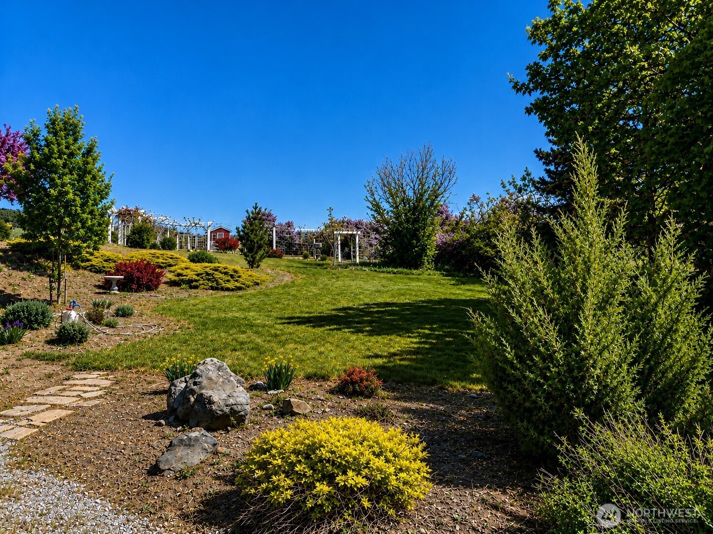 492 Pine Creek Road Tonasket, WA 98855 - Photo 33 of 37 a view of a garden with a tree