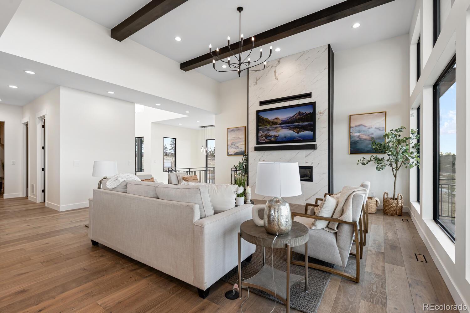 11115 Evening Hunt Road Franktown, CO 80116 - Photo 12 of 46 a living room with furniture a flat screen tv and a fireplace