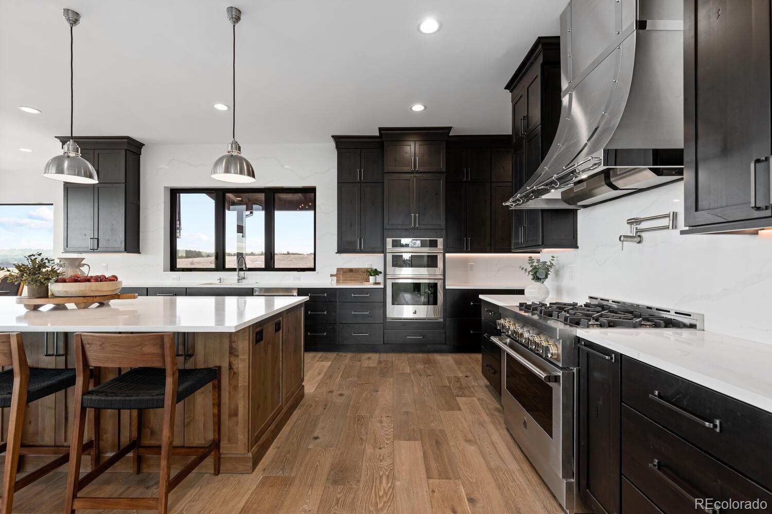 11115 Evening Hunt Road Franktown, CO 80116 - Photo 14 of 46 a kitchen with stainless steel appliances granite countertop a stove a sink and a wooden floors