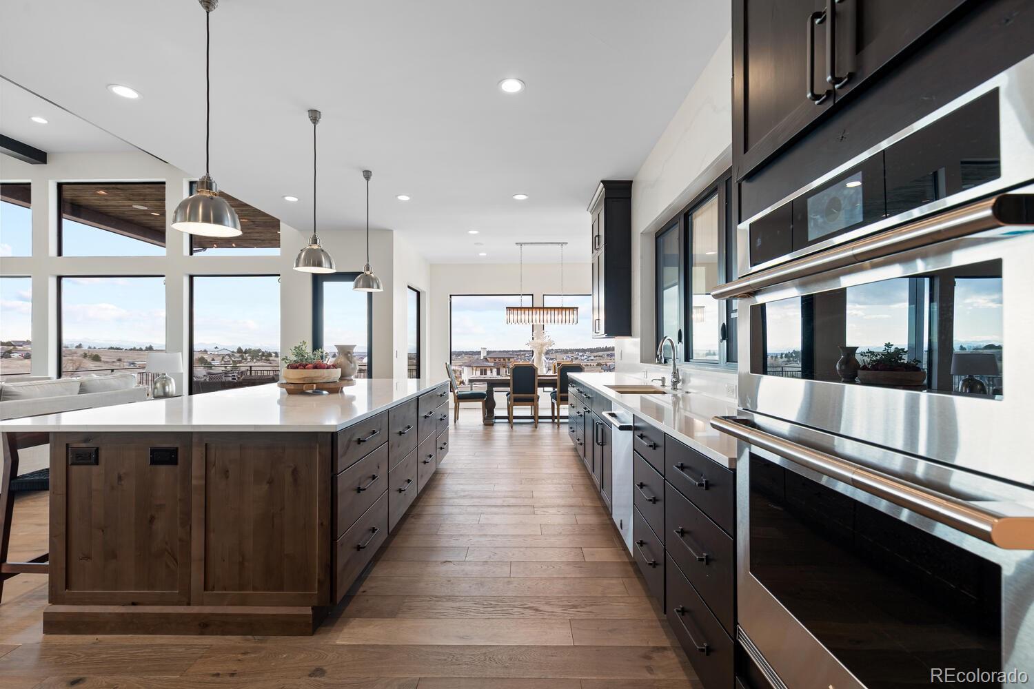 11115 Evening Hunt Road Franktown, CO 80116 - Photo 18 of 46 a large kitchen with stainless steel appliances kitchen island granite countertop a large kitchen island and a sink