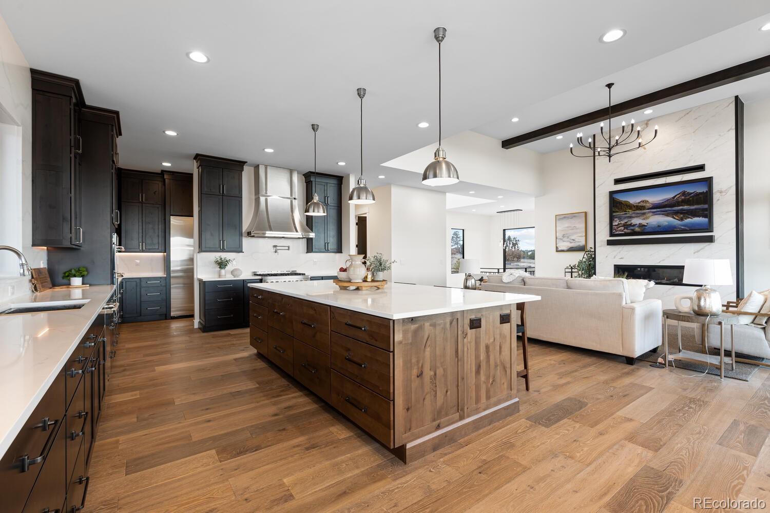 11115 Evening Hunt Road Franktown, CO 80116 - Photo 19 of 46 a large kitchen with stainless steel appliances a large center island attached withe living room